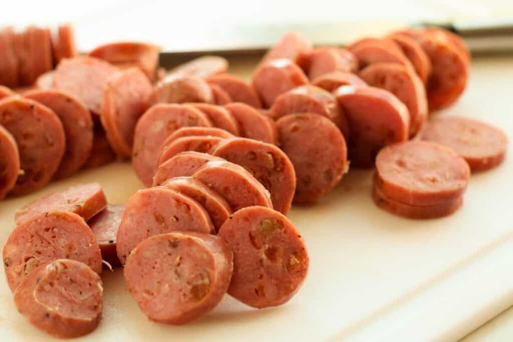 Sliced chicken sausage, on a cutting board.