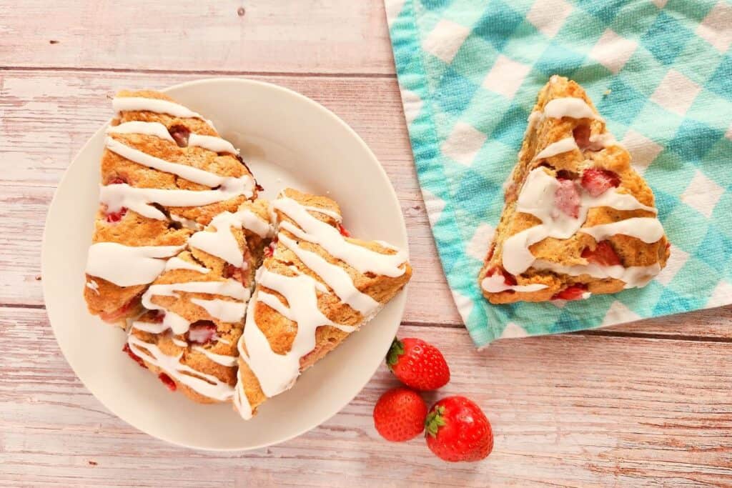 Glazed strawberry scones on a whitewashed table.