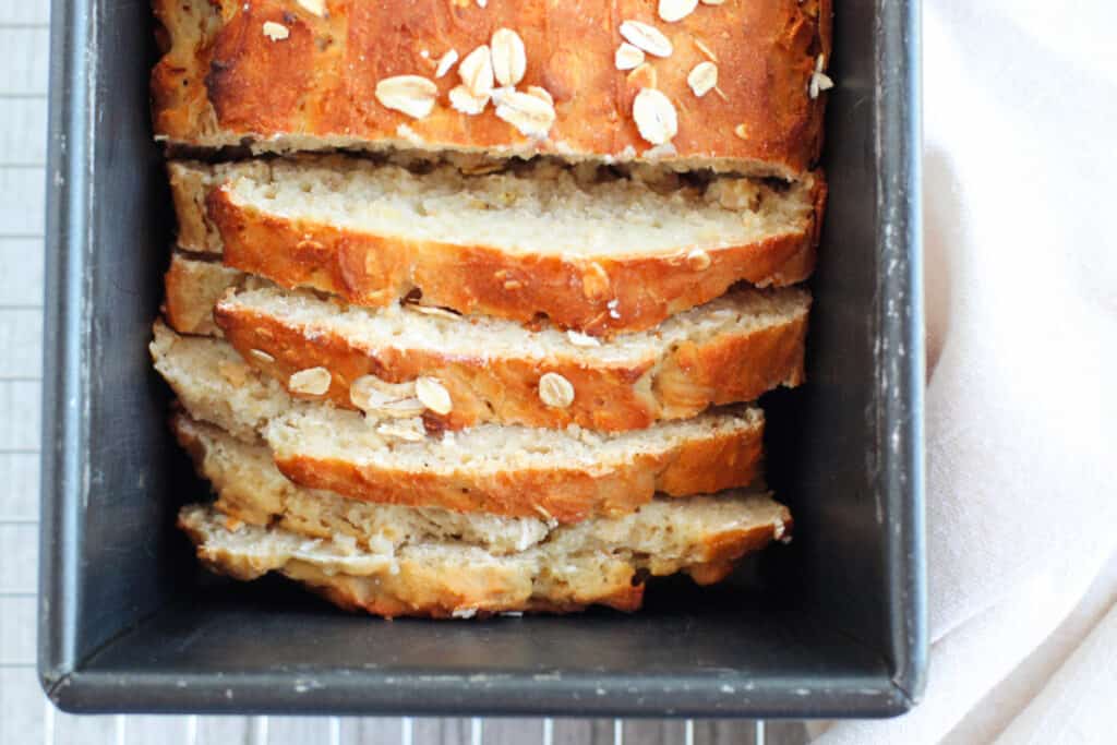 Honey oat quick bread sliced in a loaf pan. Close up image.