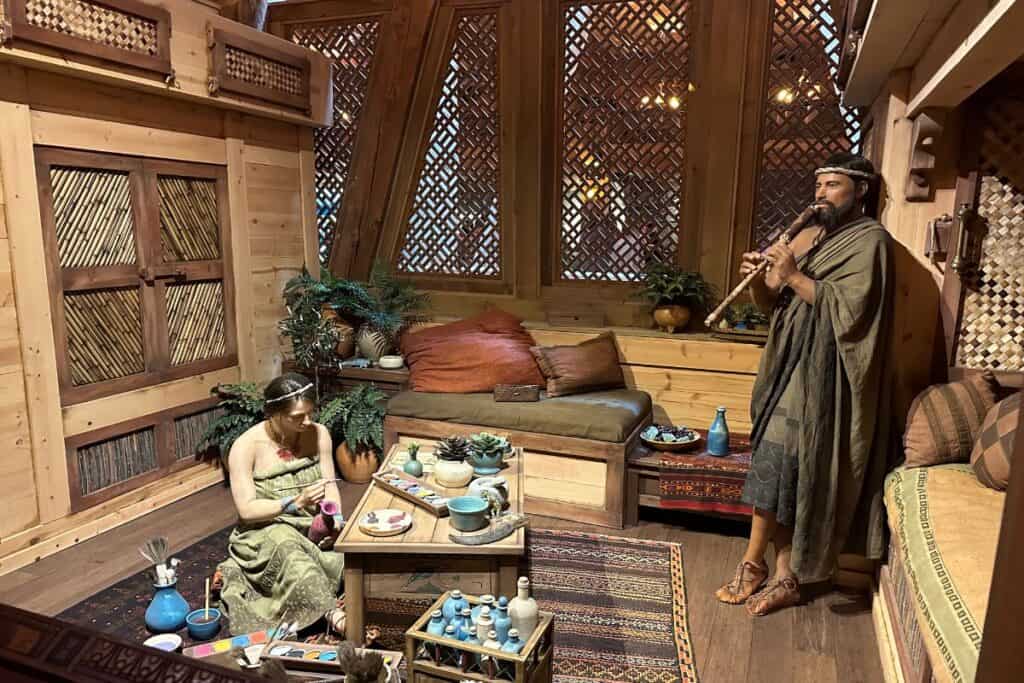 Noah's family: A man playing a flute and a woman painting pottery in the living quarter area on the Ark.