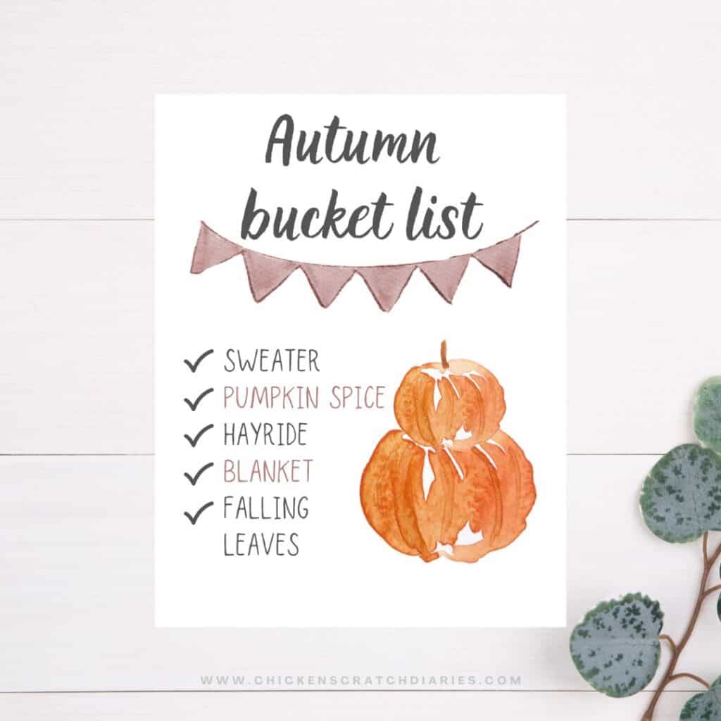 Autumn bucket list printed sign on a white wooden background.
