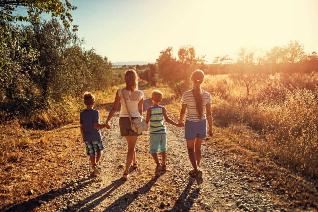 family walking outdoors on a gravel path.