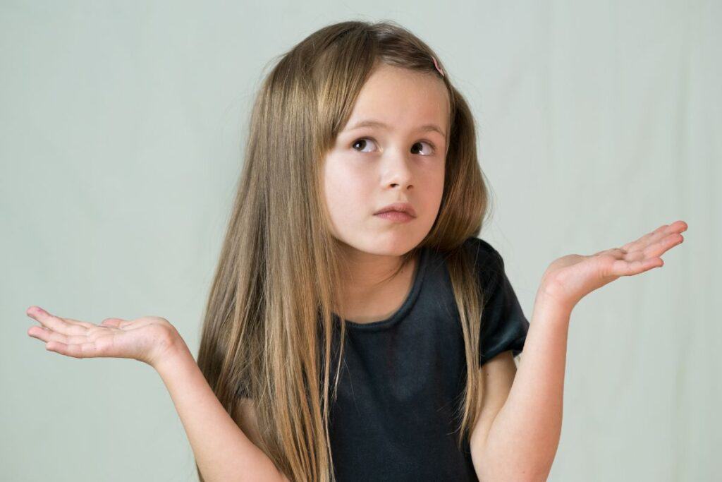 Little girl holding hands up in "I don't know" gesture.
