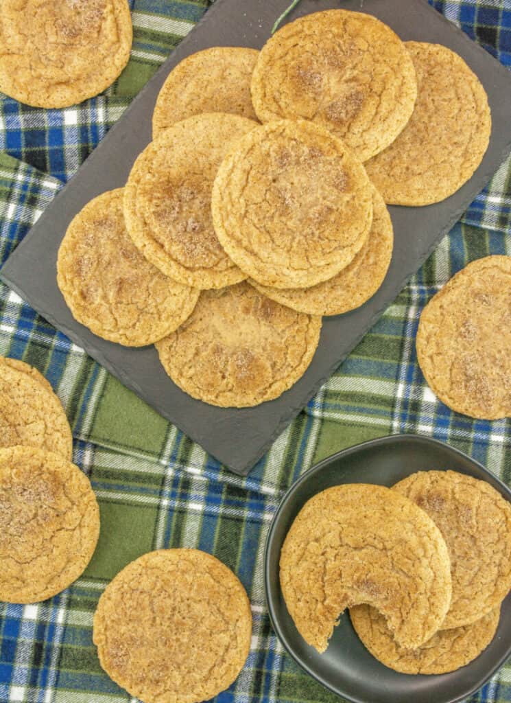 Top view of baked cookies on a stoneware platter on top of plaid flannel tablecloth.