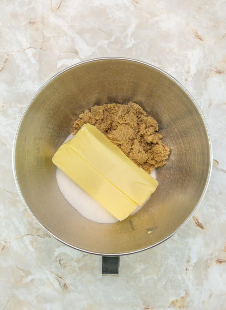 Blending butter, sugar and brown sugar in a mixing bowl of a stand mixer.