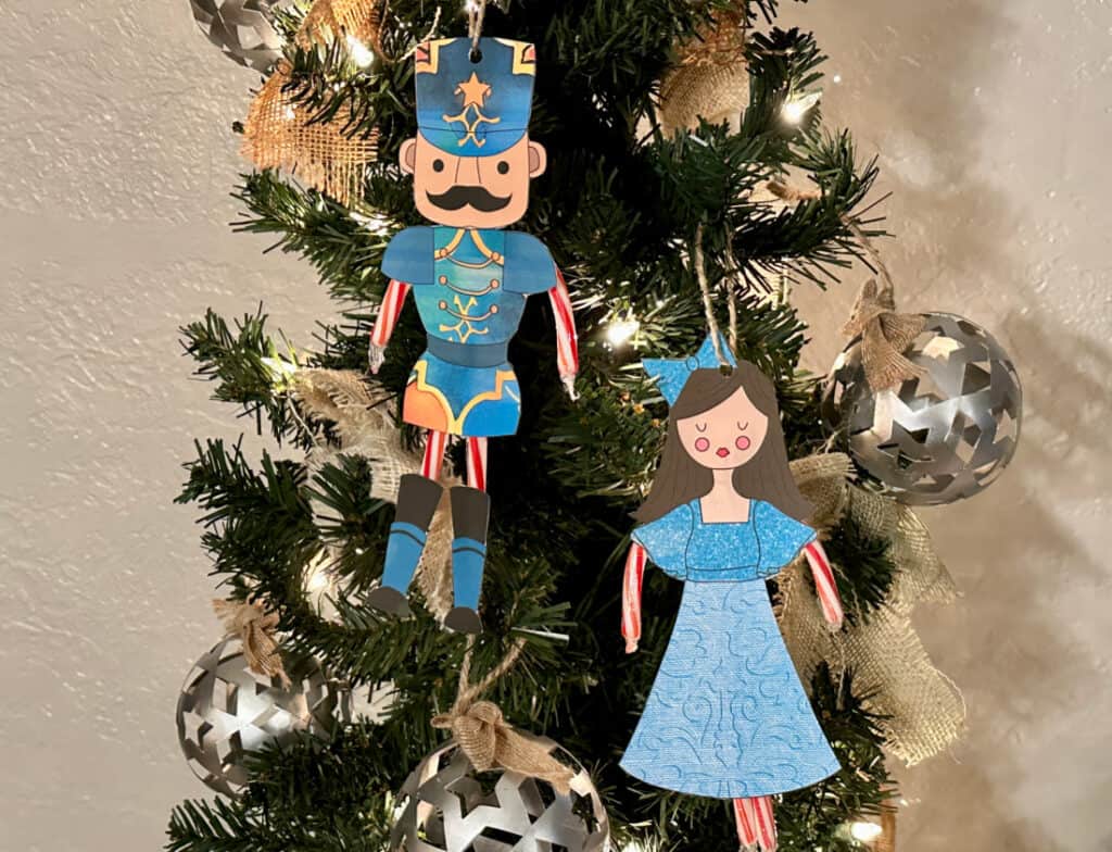 Nutcracker and Clara ornaments hanging on lighted tree