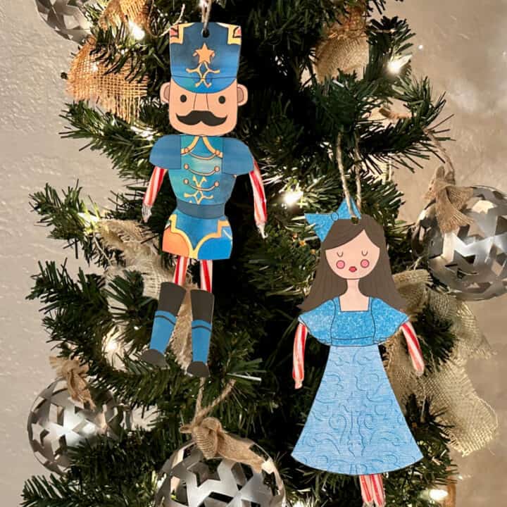 Nutcracker and Clara ornaments hanging on lighted tree
