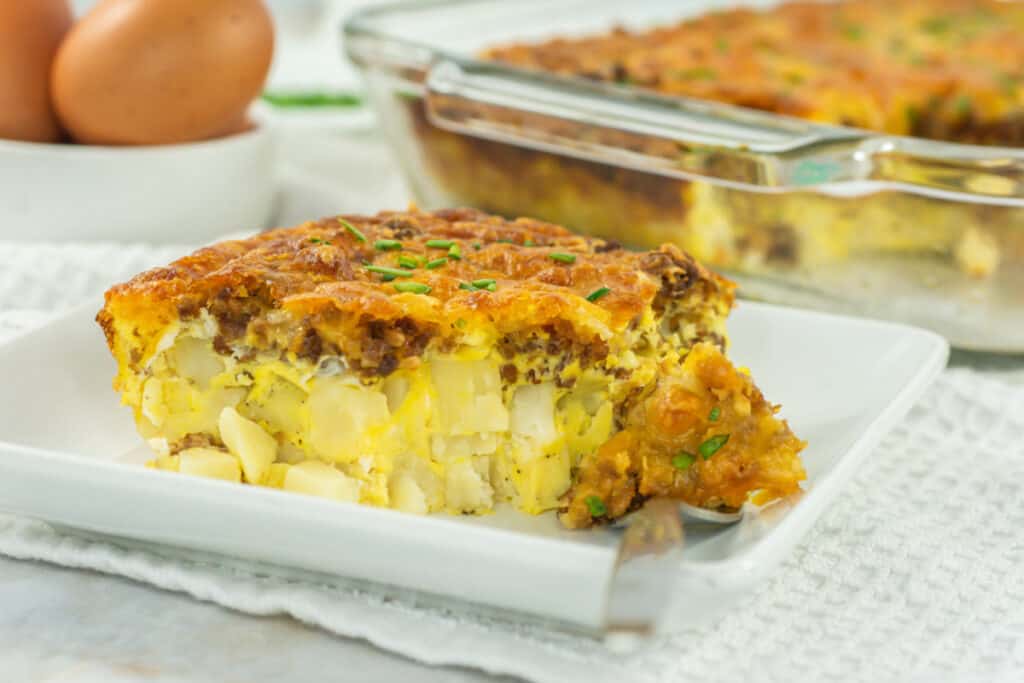 Hashbrown breakfast casserole on a plate on white placemat