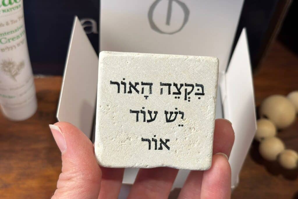 Close up of Ahava stone, with Hebrew inscription "At the end of the light, there is more light."