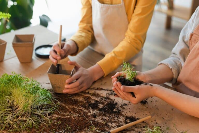 Kids potting seedlings on a work table.