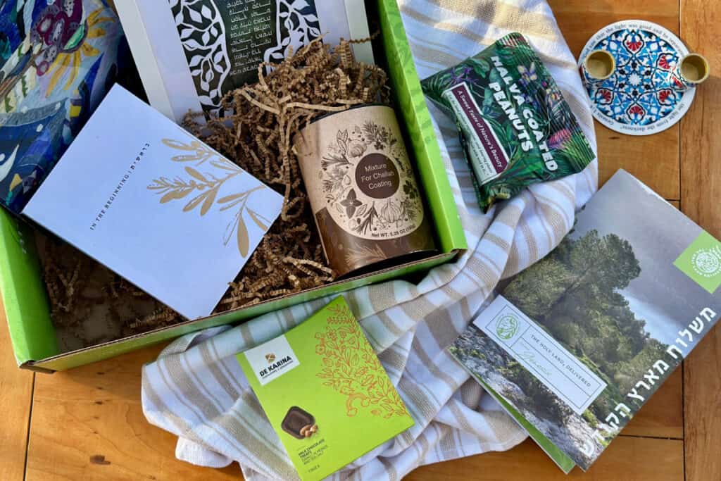Display of items from the Genesis box spread on wooden surface and in the box.