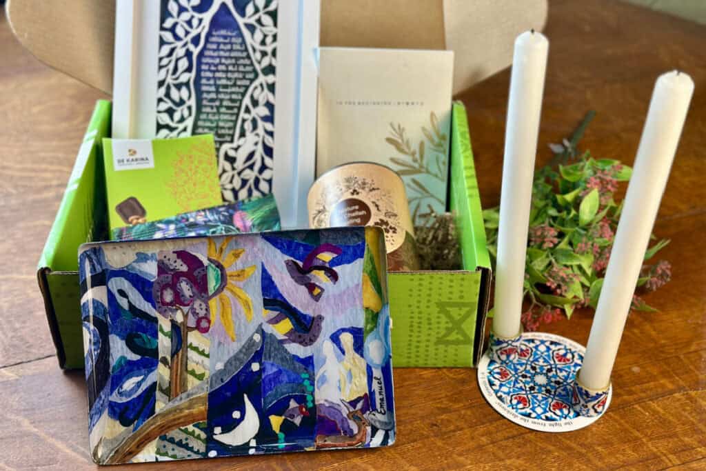 Display of the Creation serving tray, candle holder with other items in background.