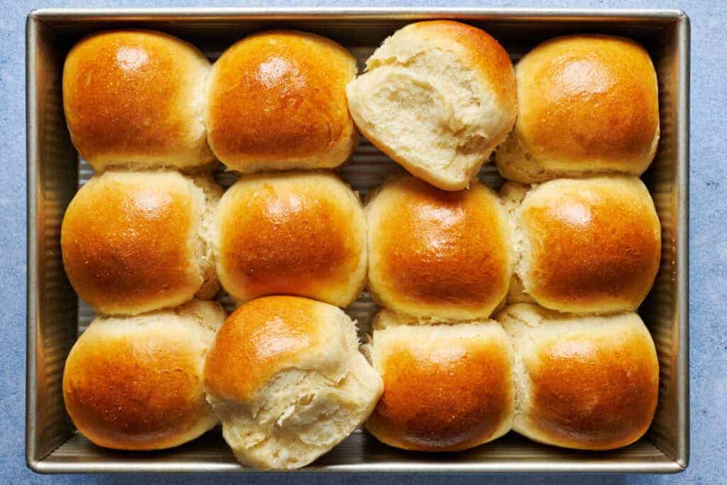 Soft baked dinner rolls in a baking pan.