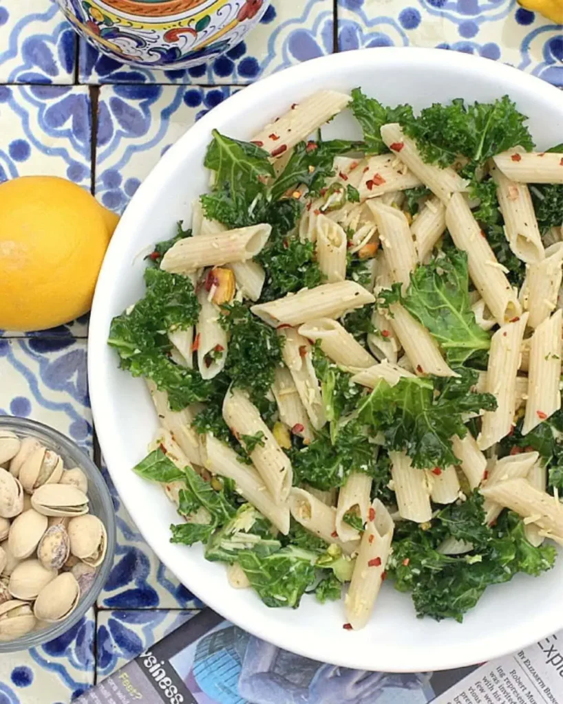 Penne salad with kale in a white bowl.
