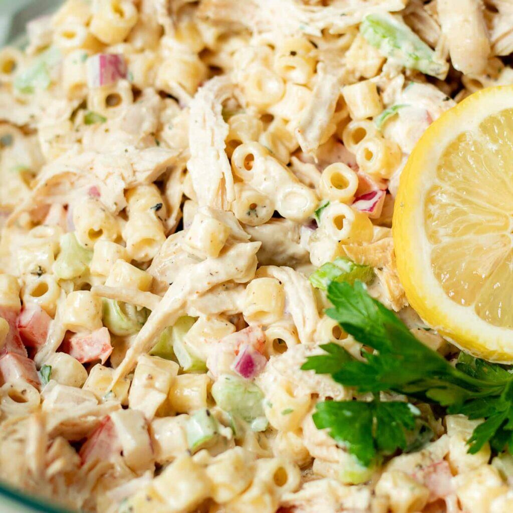 Macaroni salad with fresh parsley and lemon on top.