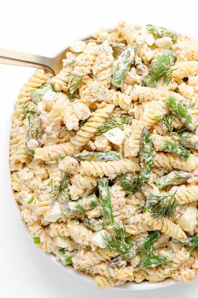 Salmon asparagus pasta with a spoon and fresh dill.