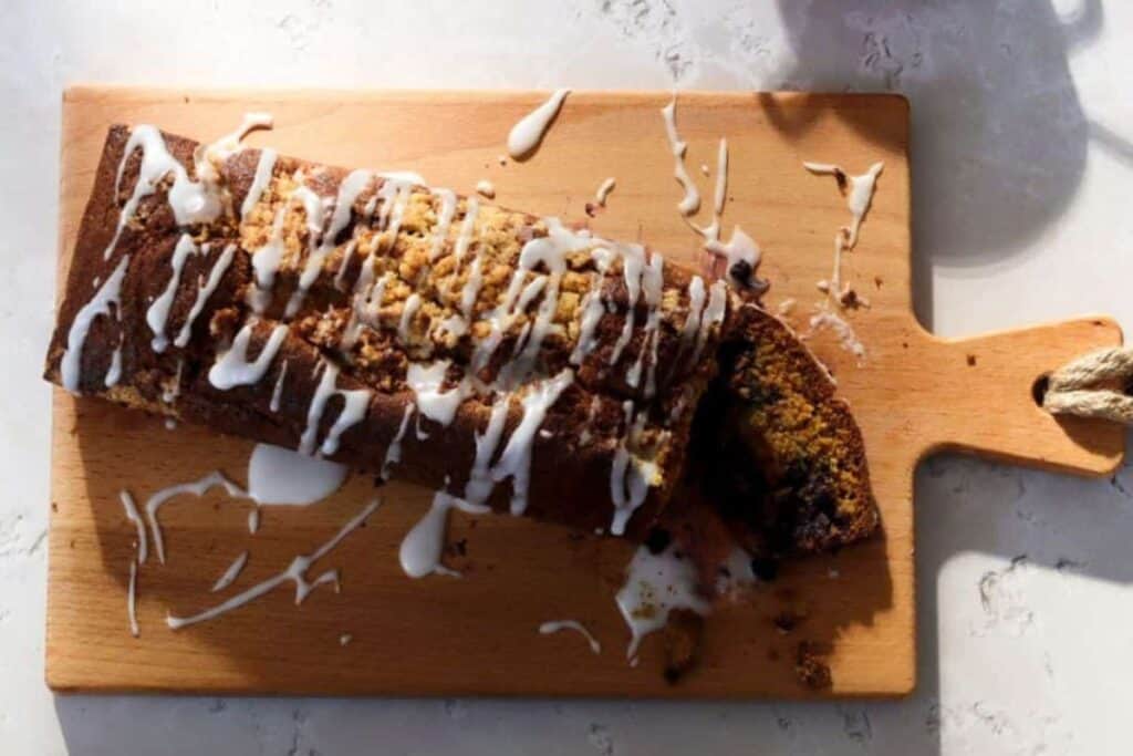 Glazed blueberry bread on cutting board.