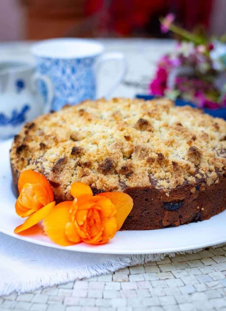 Rhubarb cake on a large plate with a flower garnish.