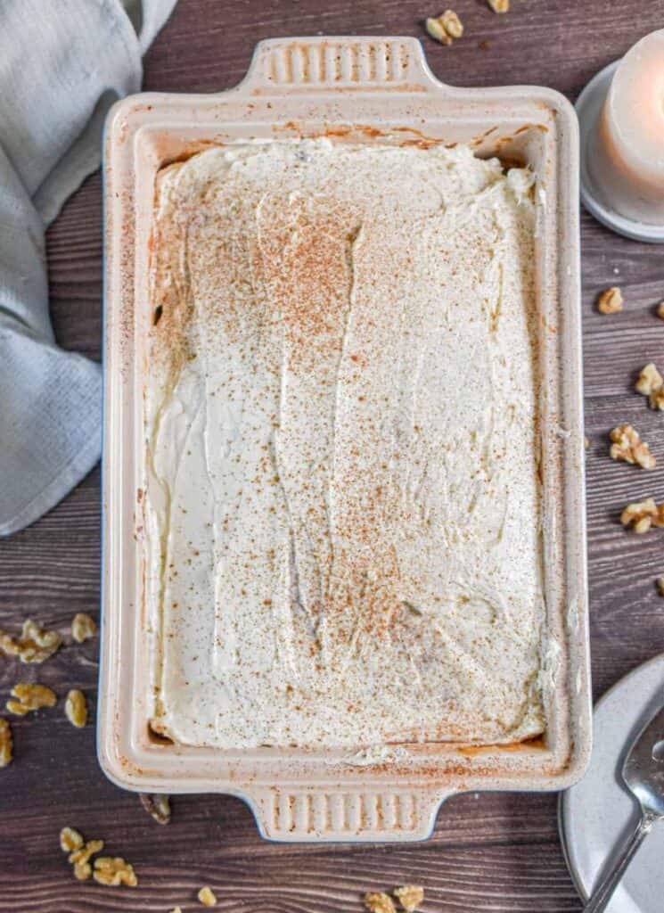 Large baking dish with sourdough discard carrot cake with frosting on top.