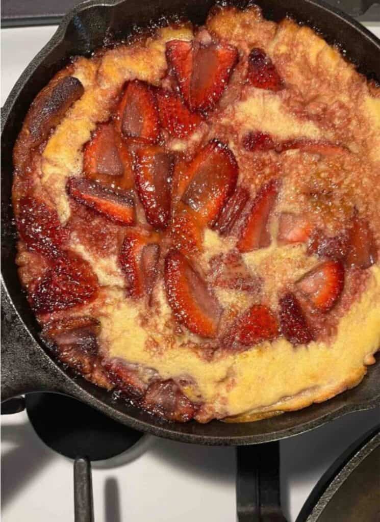 Cast iron skillet with strawberry dutch baby.