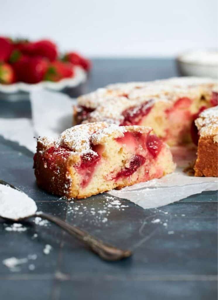 Slice of strawberry cake dusted with powdered sugar