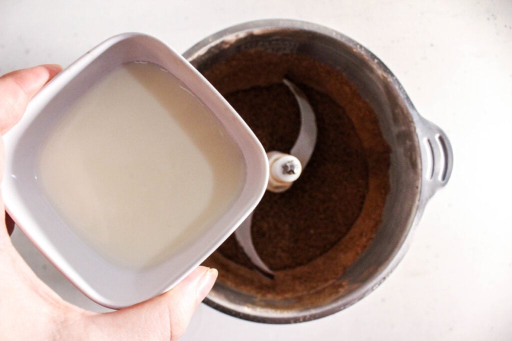 Adding milk to protein brownie mixture in blender.