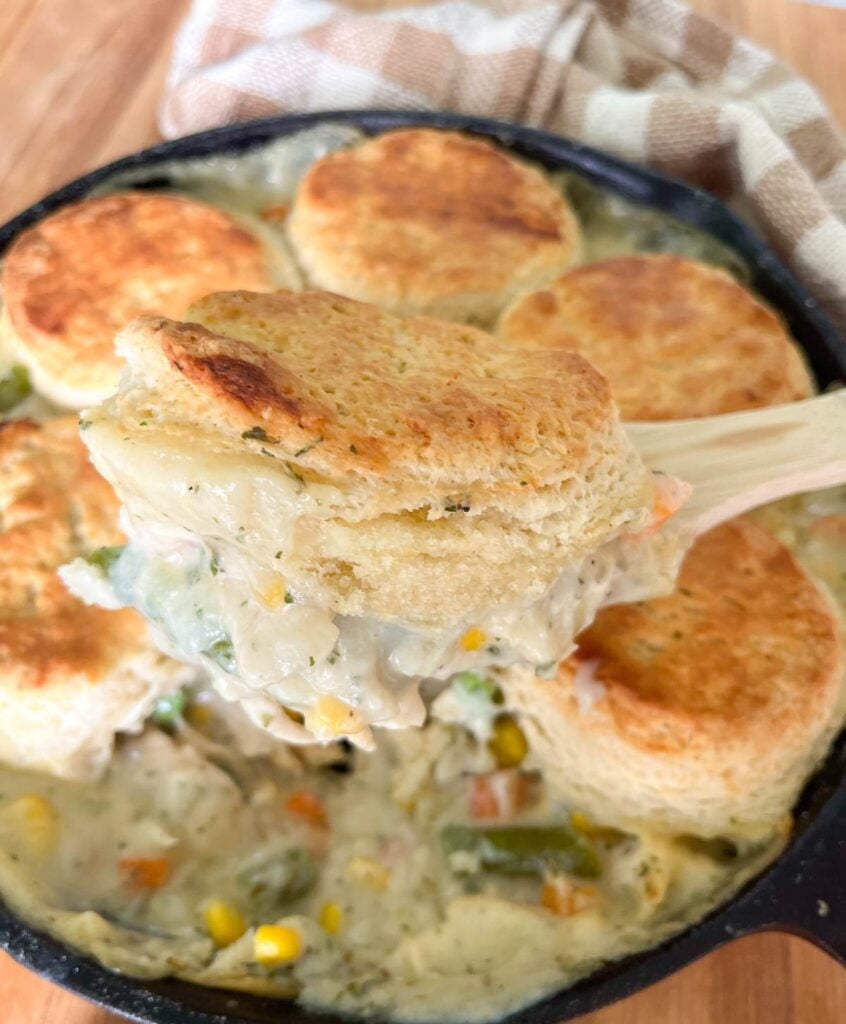 Flaky biscuits topping a sourdough chicken pot pie in a cast iron skillet.
