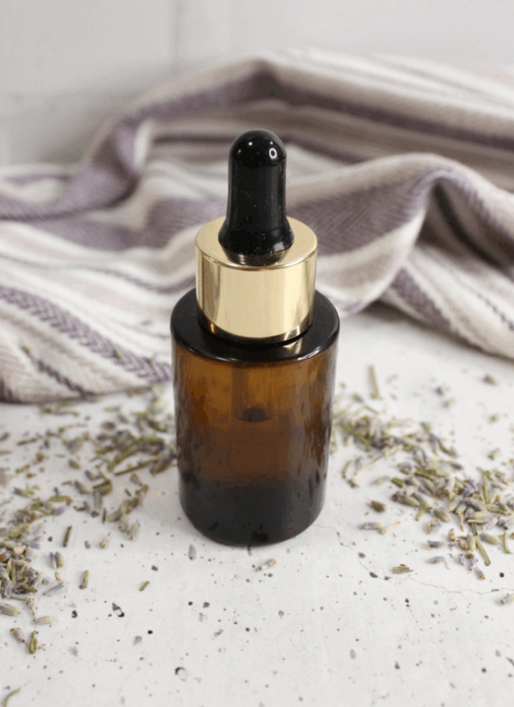 Vertical image of small amber dropper bottle of mascara remover.
